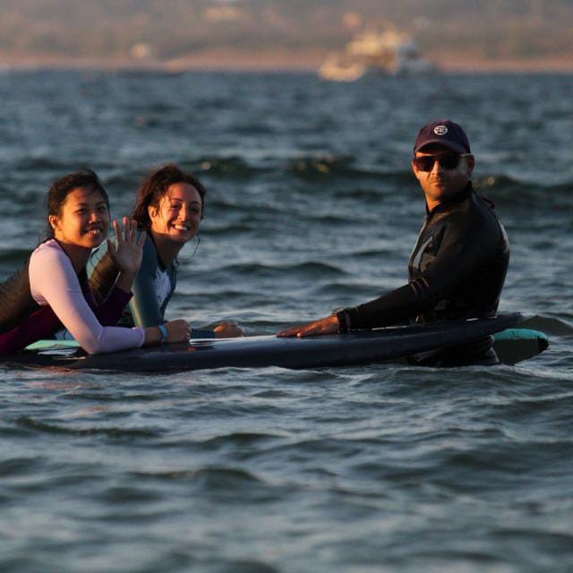 Beginner surf lesson on a sandy-bottom beach with a bilingual instructor